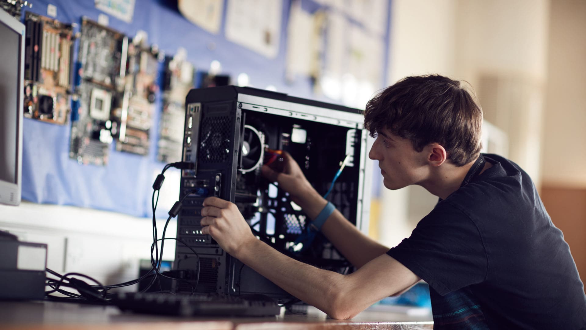 SpankBang student focusing on fixing a computer on an IT course
